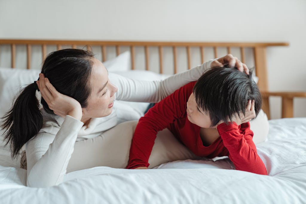 A mother and son lying on a bed having a casual conversation about the movie they just finished and comparing it to the book version.