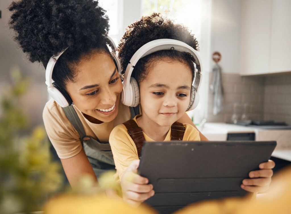 Mother and daughter listening to an audiobook from a series while following along with the e-book version.