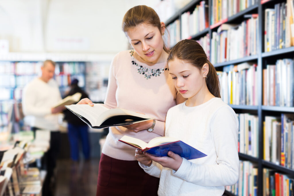 Mother and daughter browsing at a local bookstore trying to find their next binge-worthy book series.