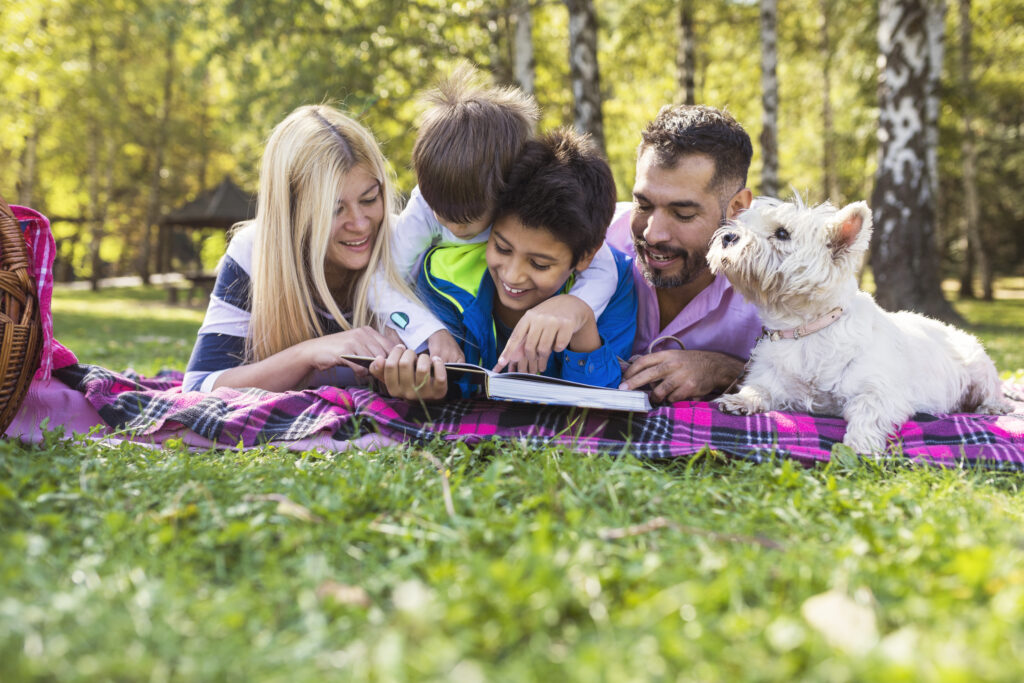 Family enjoying reading time together outdoors.
